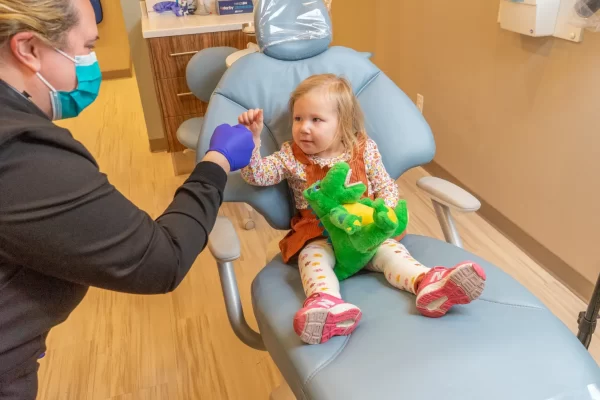 toddler girl in chair w dinosaur